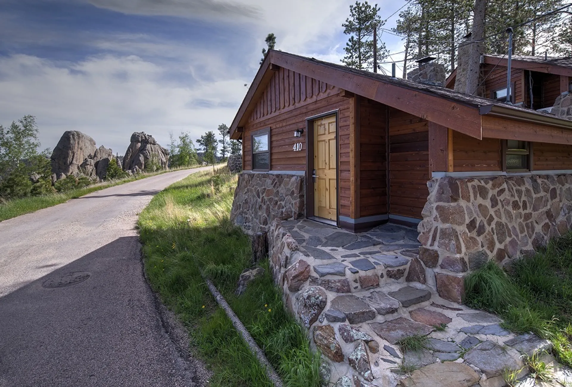 Cabin exterior with stone foundation and yellow door